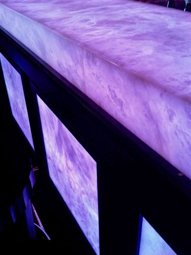Surface en marbre avec un éclairage violet, sur un cadre noir.