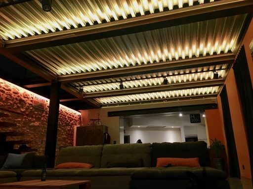 Plafond moderne avec éclairage doux dans un intérieur industriel chaleureux.